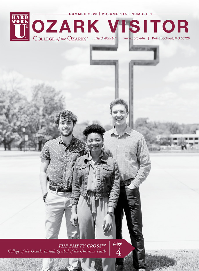 Three students standing in front of empty cross