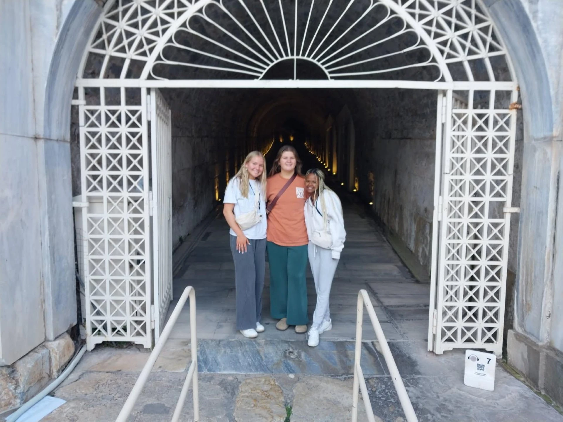 three women standing in front of a tunnel