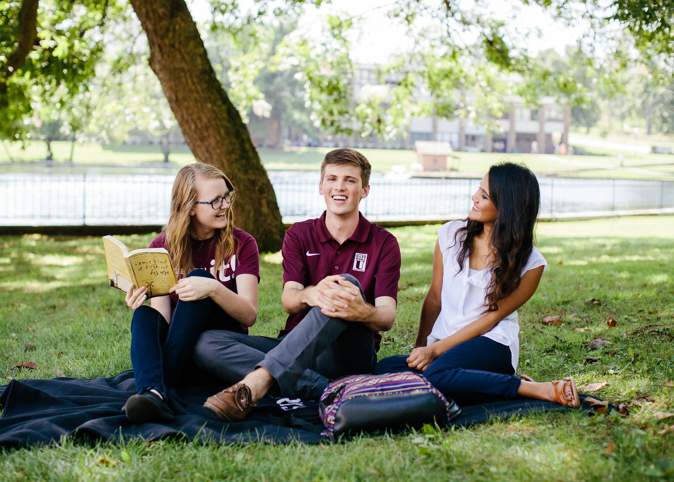 Three students sitting by Lake Honor