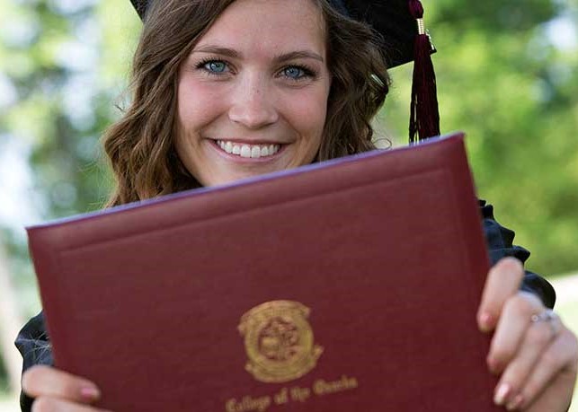 Graduate holding diploma cover