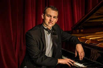 Guy sitting at a piano. 