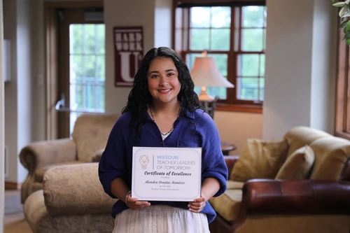 woman smiling at camera with award