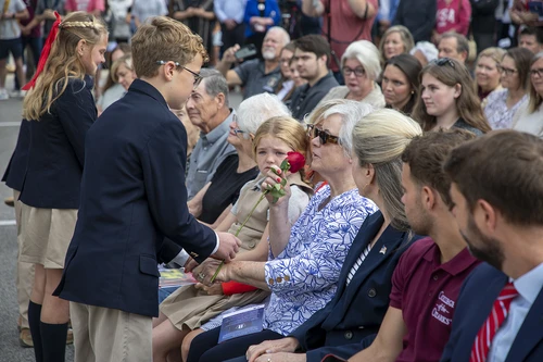 Students handing out roses.