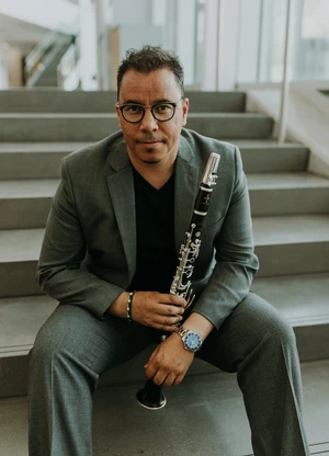 Picture of a man holding a clarinet. 