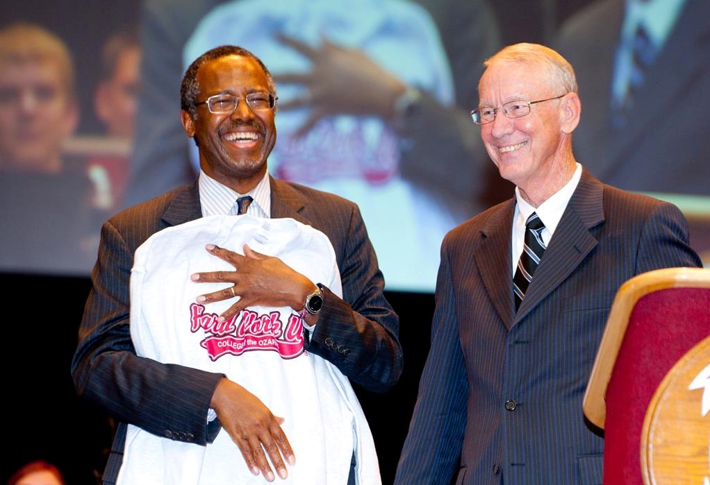 Chancellor Davis and a guest speaker holding a Hard Work U sweatshirt