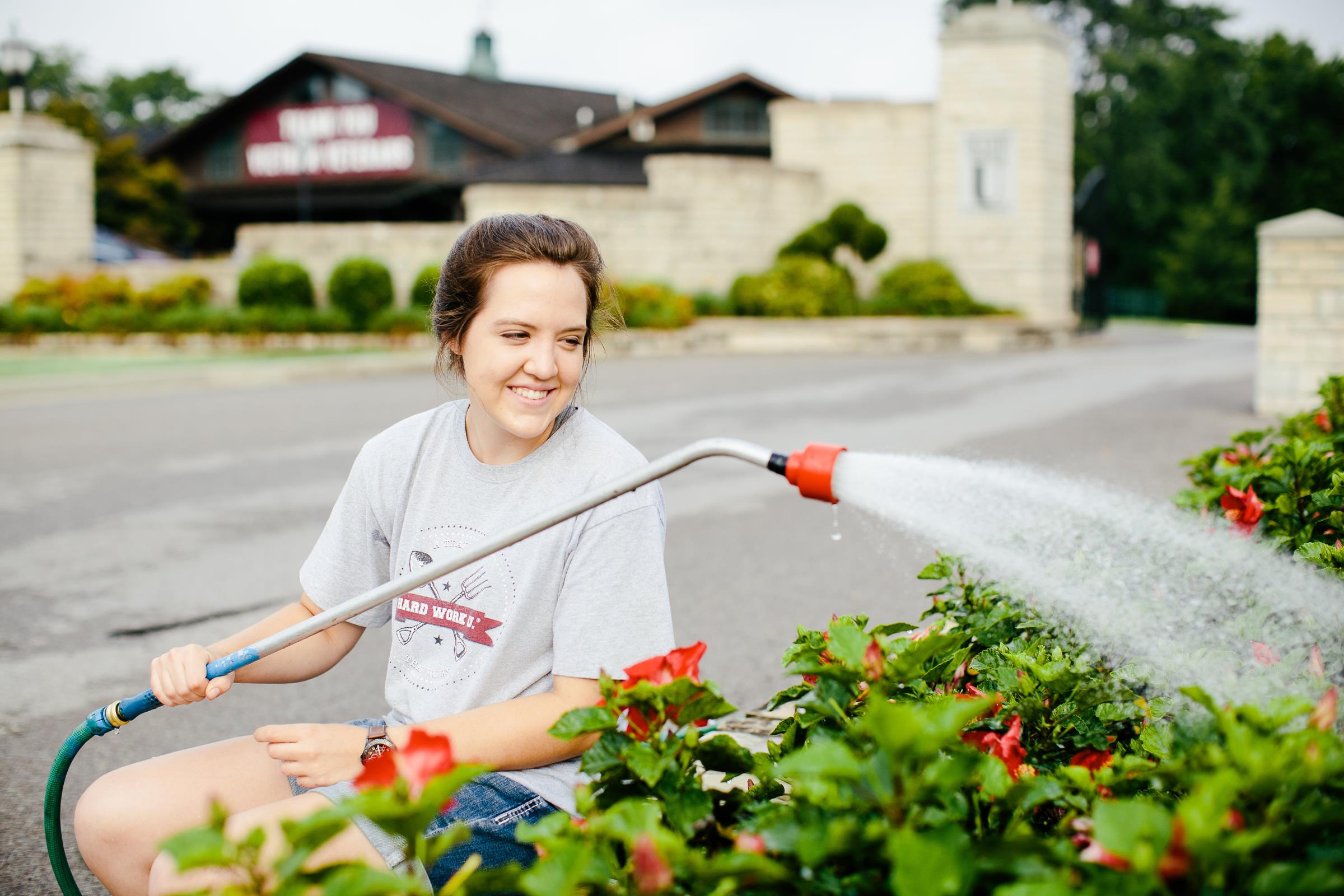 Greenhouse worker watering flowers