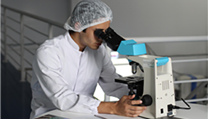 Student looking through a microscope.