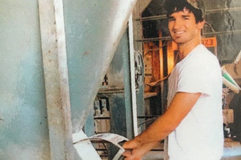 Student working machinery at the feed mill