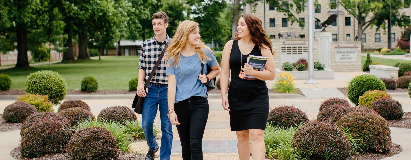 Three Students walking across campus