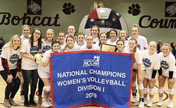 Lady Bobcats with NCCAA Division I Women’s Volleyball National Championship banner