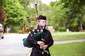 he School of the Ozarks class of 2020 is honored with music by bagpiper Amanda Kershaw, administrators in regalia, signs, and special gifts yesterday, May 7, the originally scheduled date of graduation.