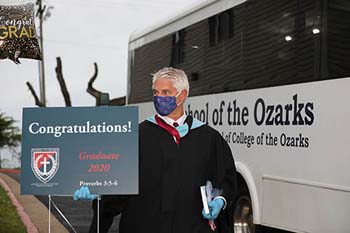 With social distancing procedures in place, Brad Dolloff disembarks from the school van to greet each graduating senior at their home.