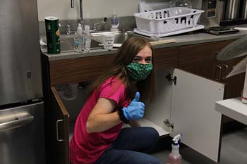 Erin Hall, senior elementary education major and Character Camp “Mom” of Family 5, cleans the kitchen of the Dee Ann White Engineering building. 