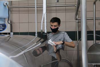 As a part of their service project, Family 3 wash and polish machinery in the W. Alton Jones Dairy. 
