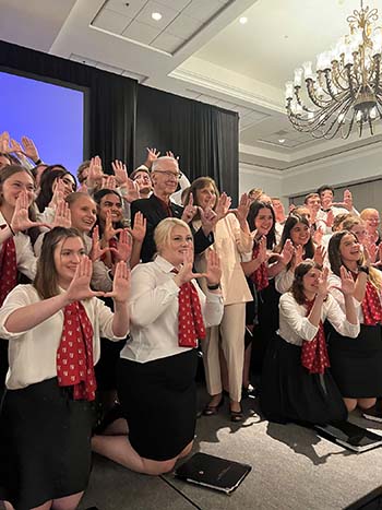 Chancellor Davis and his wife celebrate the Chapel Choir’s accomplishment with the “Hard Work U” hand symbol