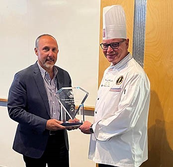 Alan Kahn, vice president of foodservice of the Idaho Potato Commission, presents the Postsecondary Educator of the Year Award to The Keeter Center Executive Chef Robert Stricklin.
