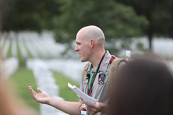 Capt. Jamin Pyatt, instructor of military science, provides information for the students at Arlington National Cemetery. 