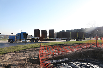 A flatbed semi brings the art through the entrance to campus. Jody Braswell, director of construction, and the C of O construction team are working to assemble the piece, which arrived on campus last week in four pieces.