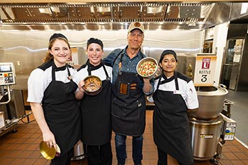 Alexandra Coufal, Rebekah Eatherly, and Claudia Verlhust, along with Mike Rowe, show their perfect designs, using nuts and fruit to top the cakes.