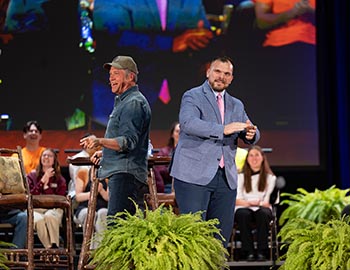 Mike Rowe and Dean of Work Education Nick Sharp enjoy a moment on stage. Sharp moderated and led a conversation about work with Rowe, primarily based on questions from students as well as Sharp.